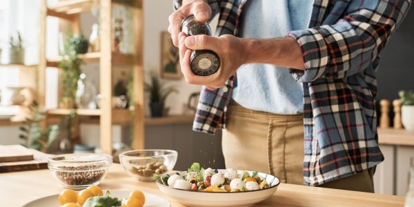 man-adding-spices-in-vegetable-salad-2023-11-27-05-35-19-utc-min